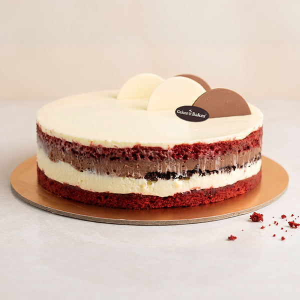 Choco Red Velvet Cake from Cakes and Bakes Bakery Dubai, decorated with chocolate swirls, fresh strawberries and blueberries for birthdays and celebrations.