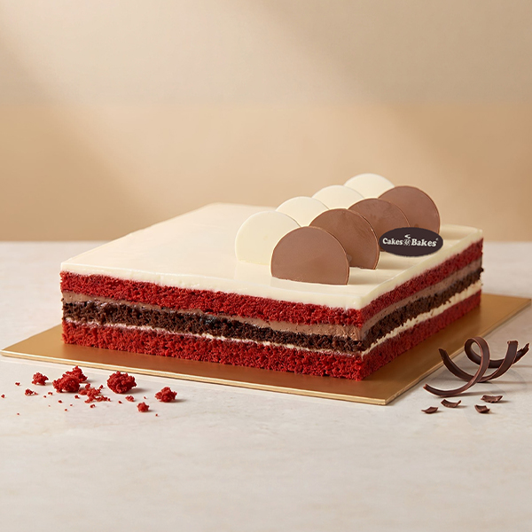Choco Red Velvet Cake from Cakes and Bakes Bakery Dubai, decorated with chocolate swirls, fresh strawberries and blueberries for birthdays and celebrations.