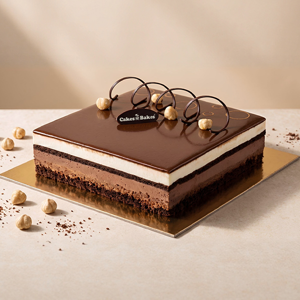 Chocolate Noisette Cake from Cakes and Bakes Bakery Dubai with glossy chocolate glaze, hazelnuts, piped chocolate decorations and crunchy praline shards.
