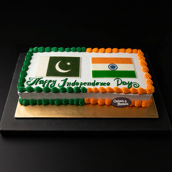 Pakistani and Indian Flags Independence Day Cake featuring both national flags, a Happy Independence Day message, and green, orange, saffron, and white cream decoration by Cakes and Bakes Bakery Dubai